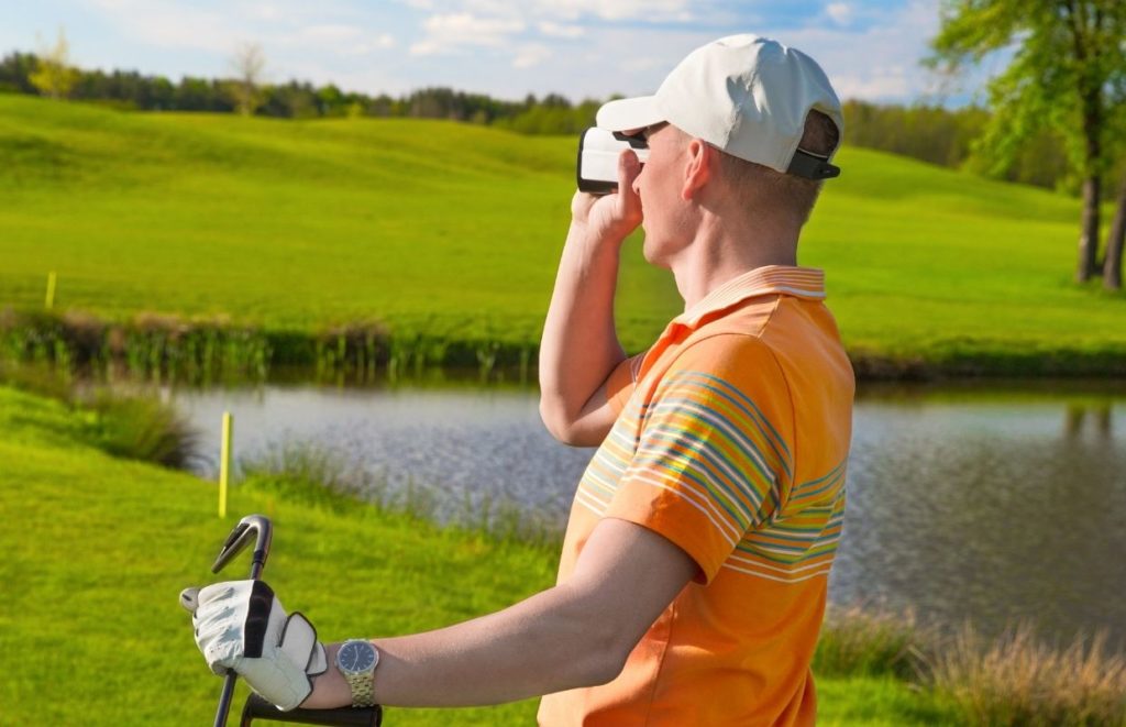 A man using a rangefinder on the golf course.