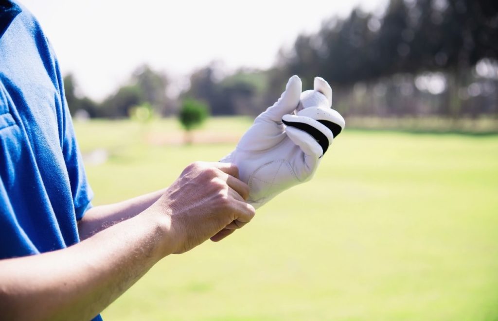 A man putting on Best Golf Gloves for Arthritic Hands