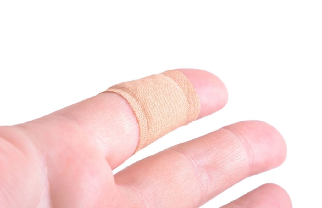 A band-aid wrapped around a blister on an index finger