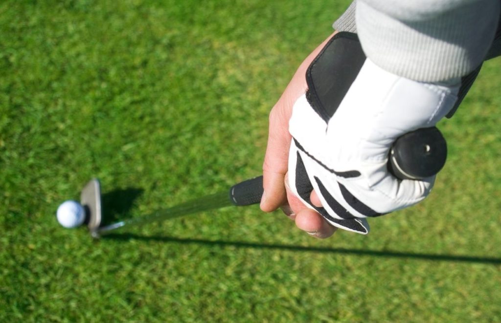 A man gripping a golf club when about to take a shot