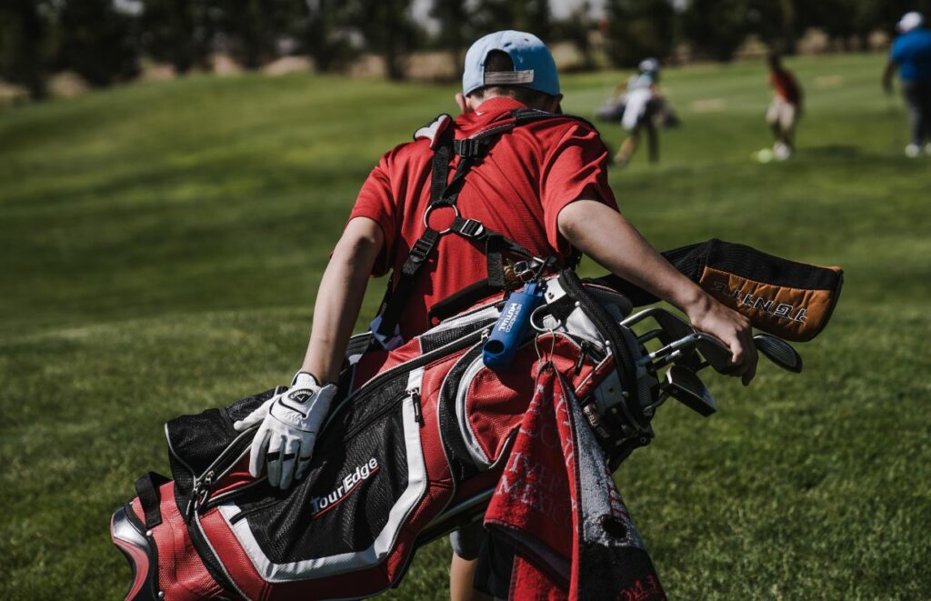 A man with a double strap golf bag on his back