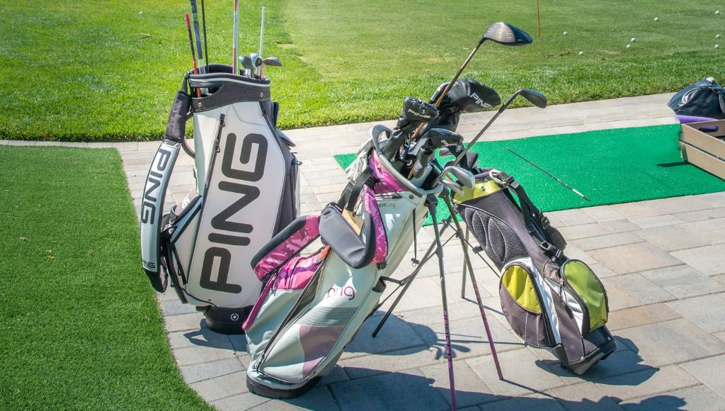Three golf bags at driving range