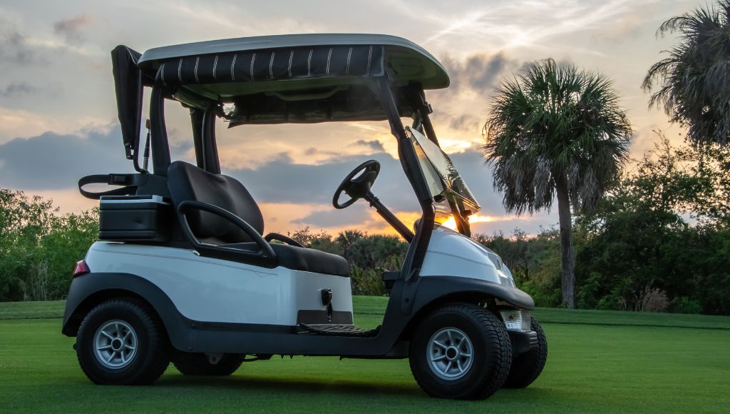 A scenario of golf cart on golf course at sunset